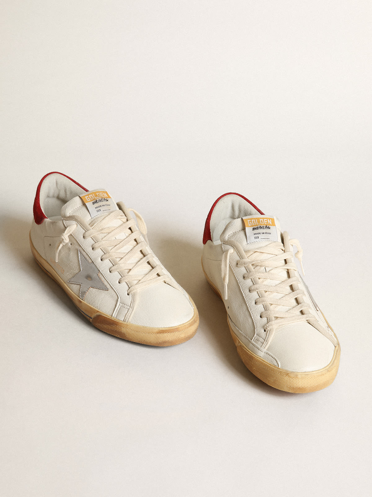 Sneaker Super-Star con stella in pelle laminata color argento e talloncino in suede rosso