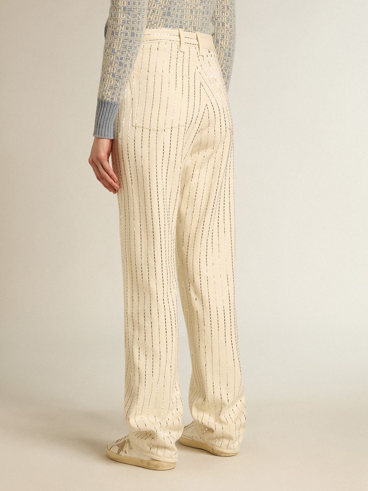 Pantalone di colore bianco con borchie a baguette applicate